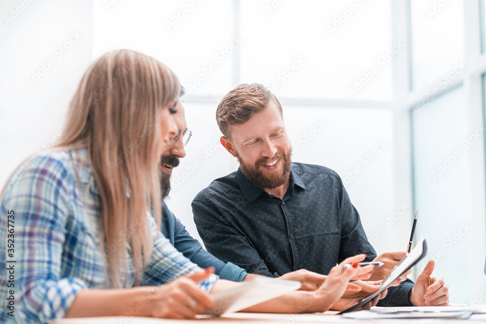 smiling staff discussing financial documents at the meeting smiling staff discussing financial documents at the meeting