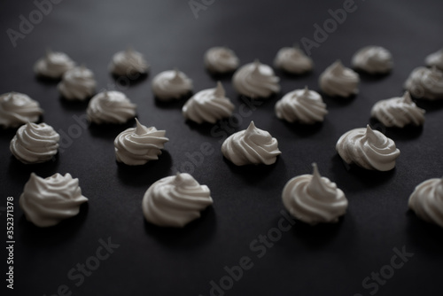 A popular French meringue dessert on a black background. Side view