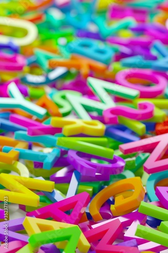 Heap of colorful rainbow alphabetic plastic character letters background, literature, education, know-how or writing concept