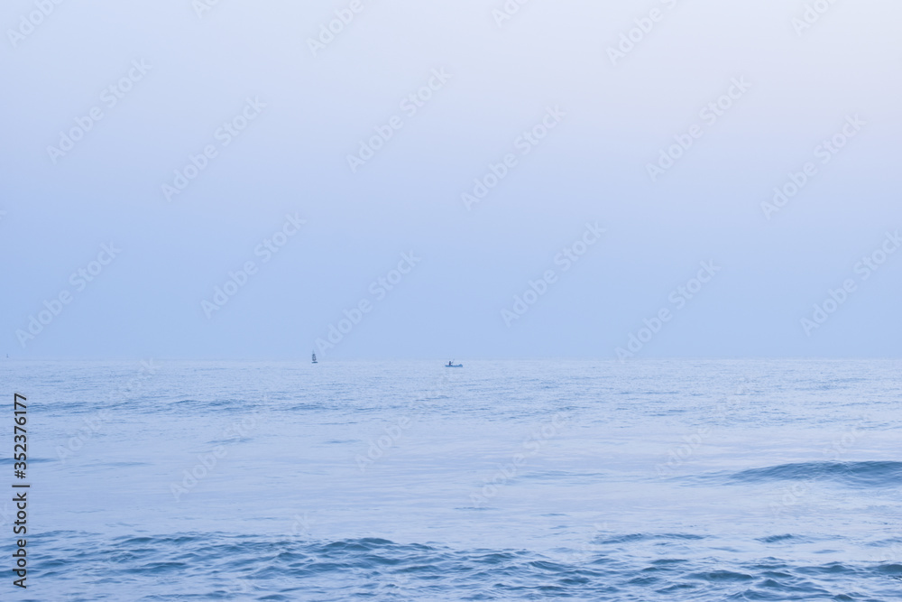 Fototapeta premium two boats in the sea. This picture is a blue tone.
