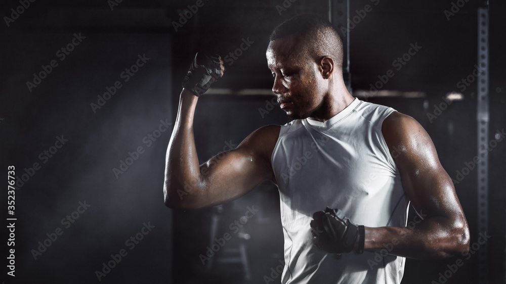 Obraz premium sport portrait of african american athletics strong bodybuilder man posing show his muscle in gym in dark tone
