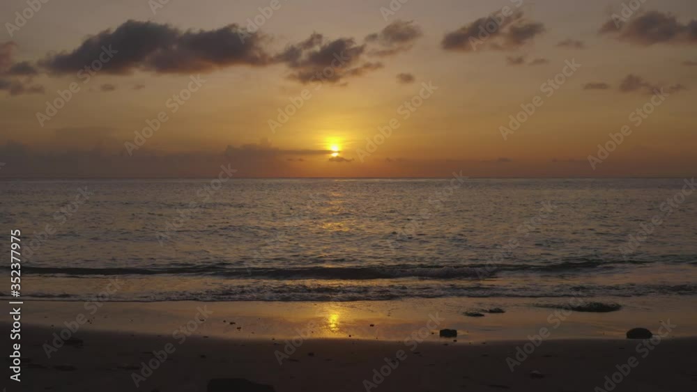 Sunset over the ocean near Amed, Bali. Slow drone forward over the sand and then onto the open ocean Sunset over the ocean near Amed, Bali. Slow drone forward over the sand and then onto the open ocean