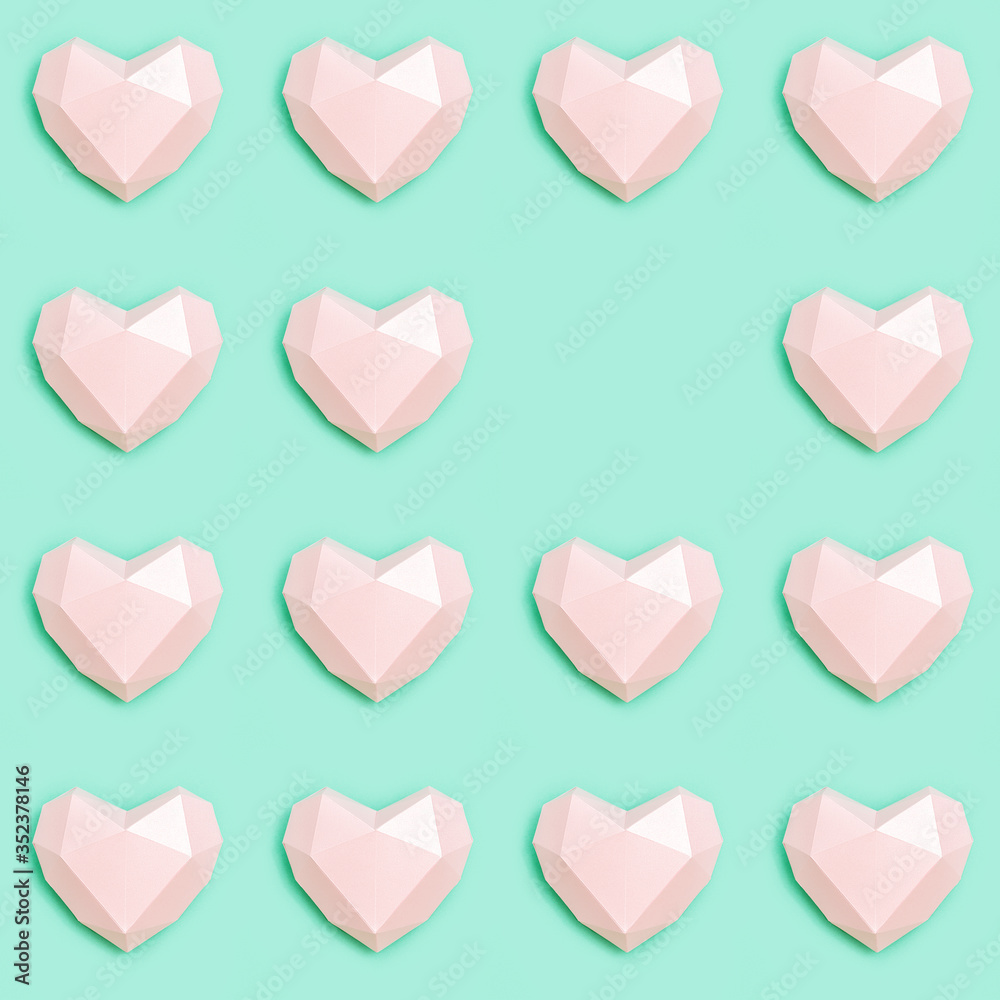 Creative Flat lay with Pink polygonal paper heart shape on mint color paper.  Love concept. Pastel colored pattern. Minimal style.