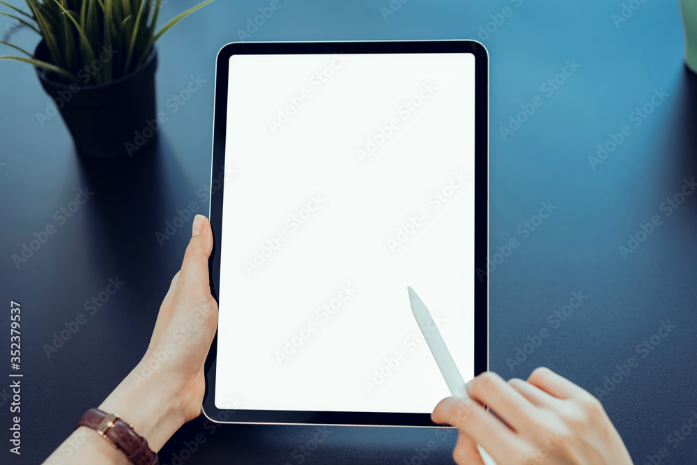 Closeup of woman hand holding digital tablet on the table and the screen is blank. Closeup of woman hand holding digital tablet on the table and the screen is blank.