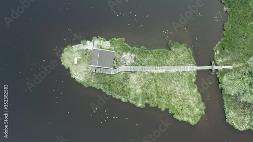 A small wooden shed in the middle if the beautiful Hackensee Lake in Germany during low tide - top view aerial photo