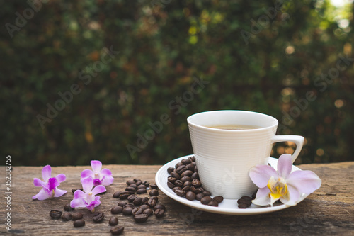 Cup coffee, Phaleanopsis  and roasted coffee bean on wooden table. photo