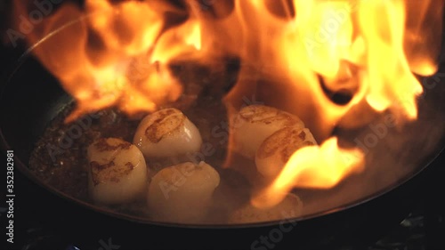the chef is cooking scallops. Scallop is cooking in a pan. Someone's cooking seafood. Close-up of the scallop.