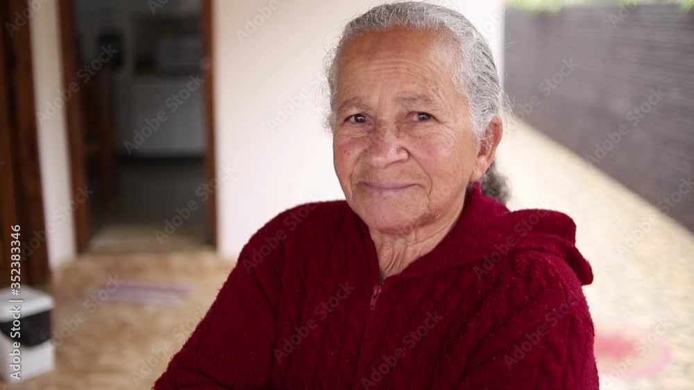 Retrato da mulher idosa de sorriso bonita com cabelo branco e braços cruzados e expressão alegre.