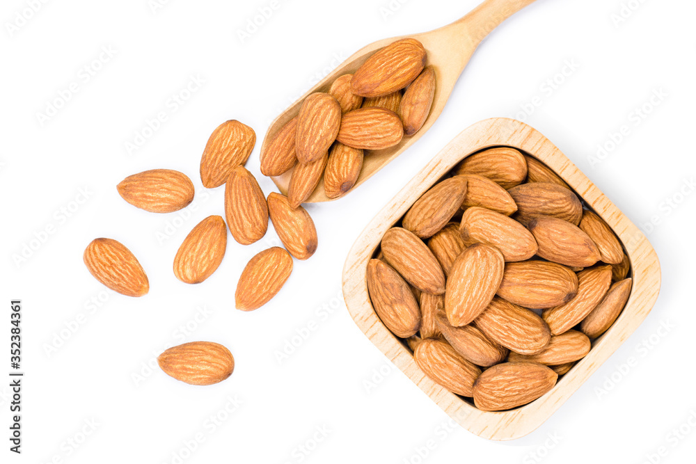 Closeup brown Almond seeds in wooden bowl and scoop isolated on white background. Top view. Flat lay. Closeup brown Almond seeds in wooden bowl and scoop isolated on white background. Top view. Flat lay.