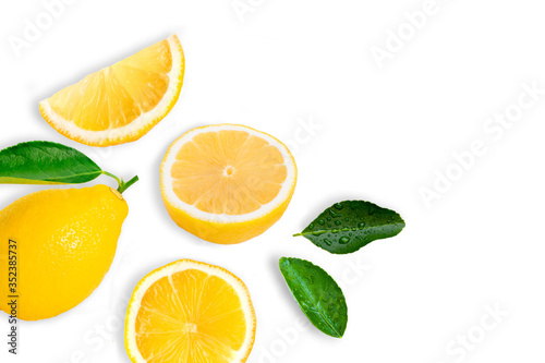 Fresh organic yellow lemon with sliced and green leaves isolated on white background . Top view.
