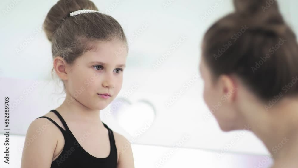 Cute Female ballet teacher gives his sad student a toy to calm her Cute Female ballet teacher gives his sad student a toy to calm her