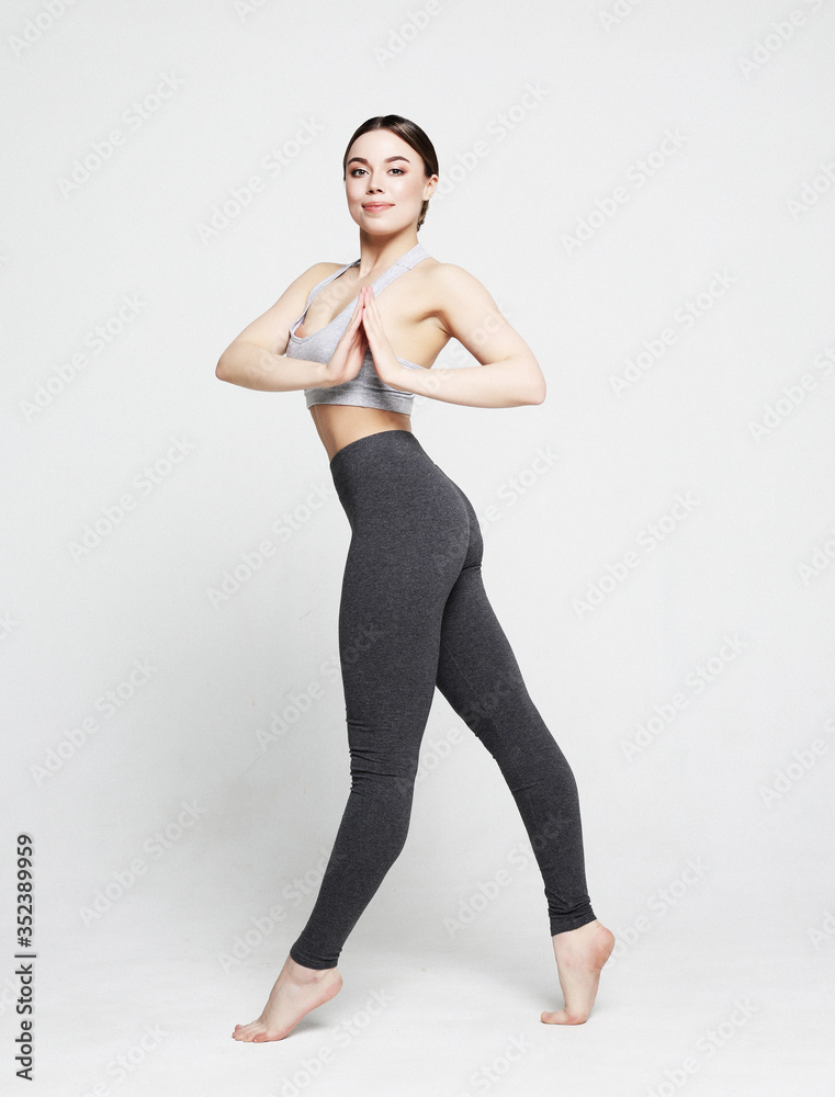 Fit and healthy woman. Happy fitness woman in sportwear jumping over white studio background. Fit and healthy woman. Happy fitness woman in sportwear jumping over white studio background.