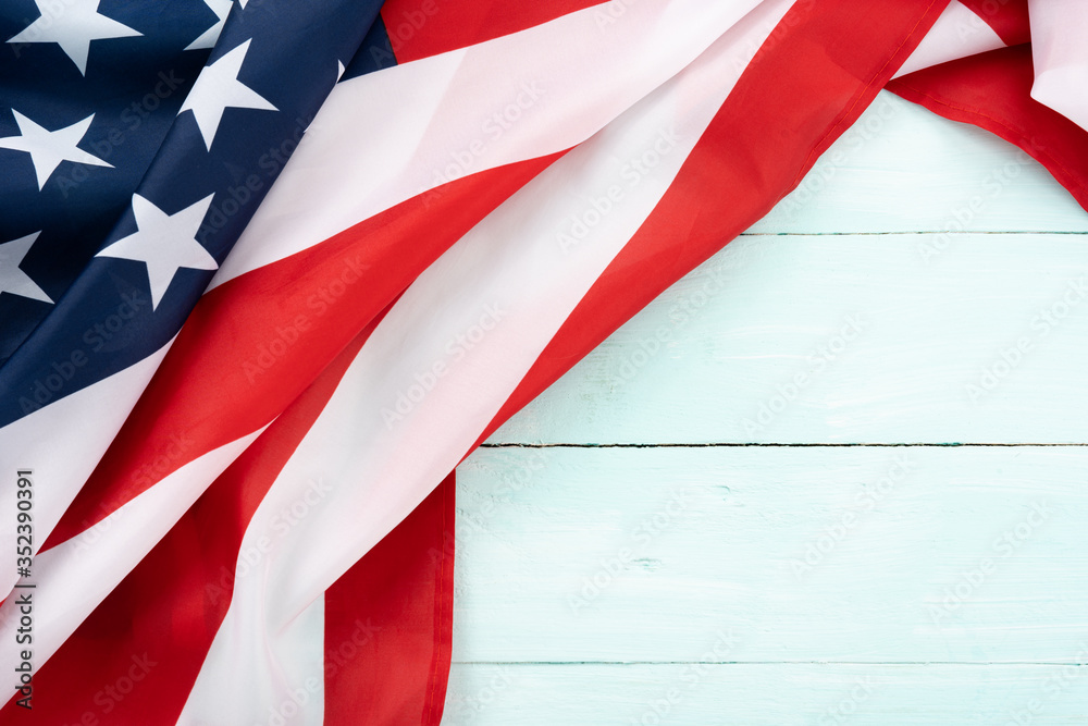 Fototapeta premium US American flag on blue wooden background. For USA Memorial day, Presidents day, Veterans day, Labor day, Independence or 4th of July celebration. Top view, copy space for text.