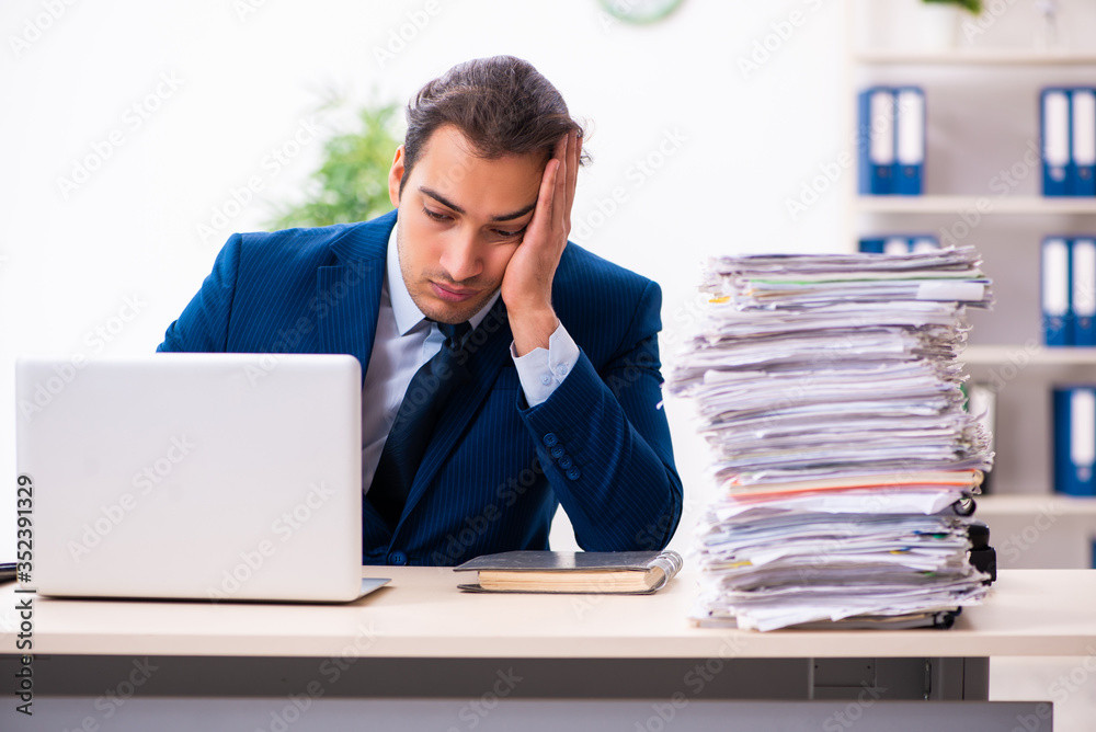 Young male employee unhappy with excessive work Young male employee unhappy with excessive work