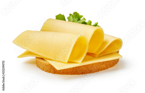 Cheese slices with salad leaf on piece of bread. Sandwich isolated on white background. photo