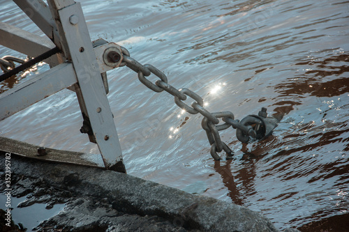 Anchor chain in the water on the pier