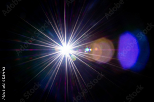 Lense flare sunlight ray. Sun shine flash effect or star spot glow light on black background. Gleams rounded and hexagonal shapes, rainbow halo.