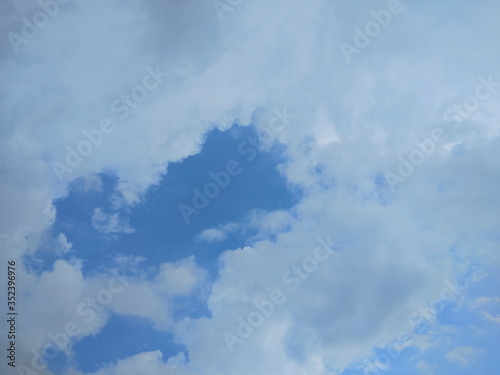 Ant's eye view of white clouds moving with blue sky background.