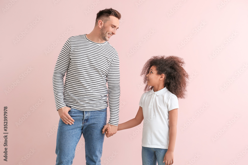Happy man with little adopted girl on color background Happy man with little adopted girl on color background