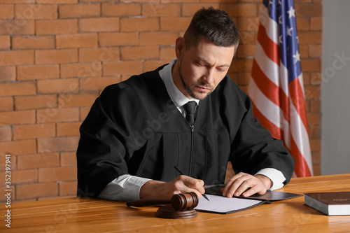 Male judge signing document...