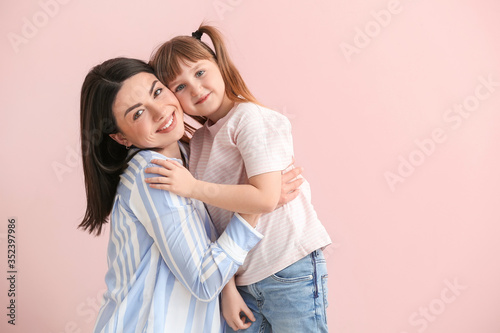 Happy woman with little adopted girl on color background