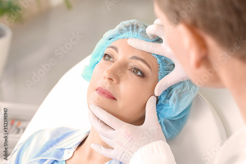 Plastic surgeon examining w...