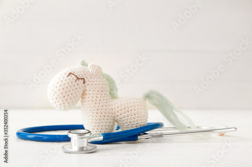 Toy with stethoscope on white background