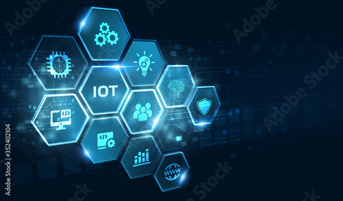 Internet of things - IOT concept. Businessman offer IOT products and solutions. Young businessman select the abstract chip with text IoT on the virtual display.