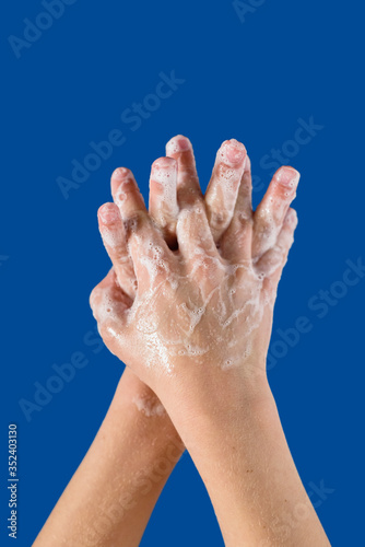 Kid showing how to wash hands to prevent virus desease, on blue background