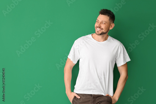 Man in stylish t-shirt on color background