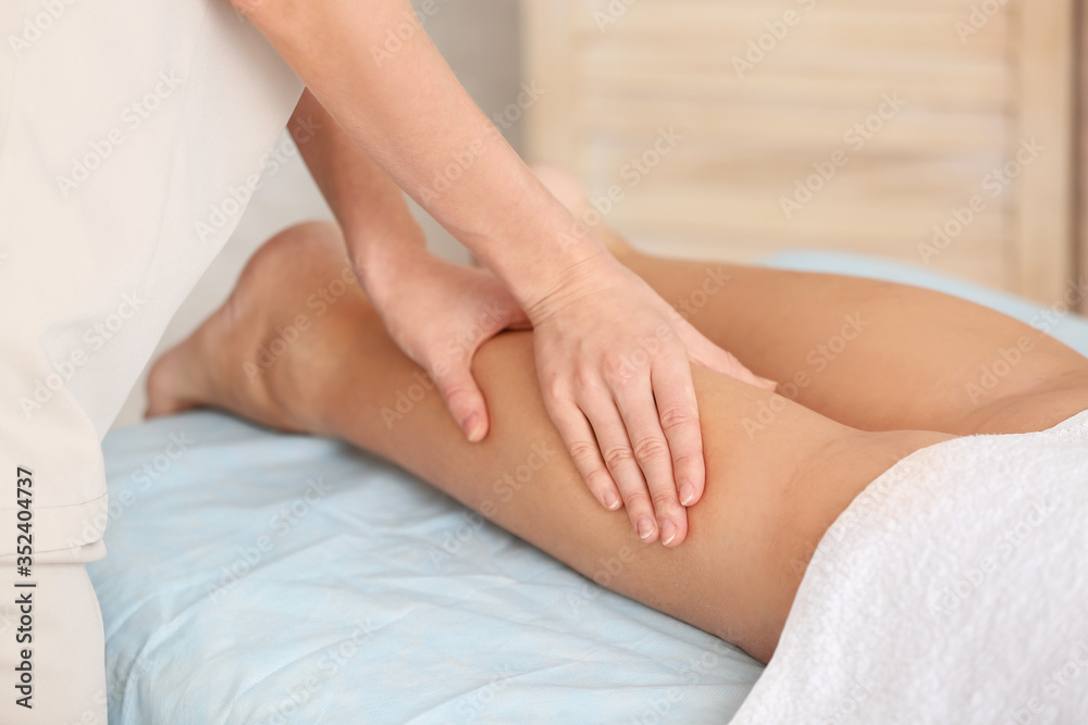 Massage therapist working with female patient in medical center