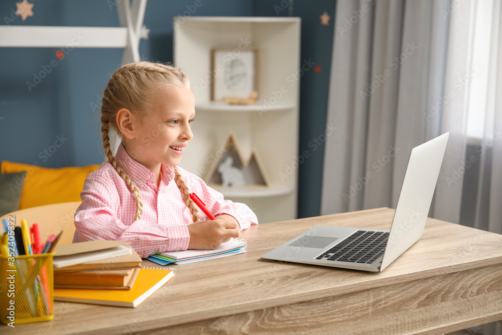 Cute little girl studying at home. Concept of online education Cute little girl studying at home. Concept of online education