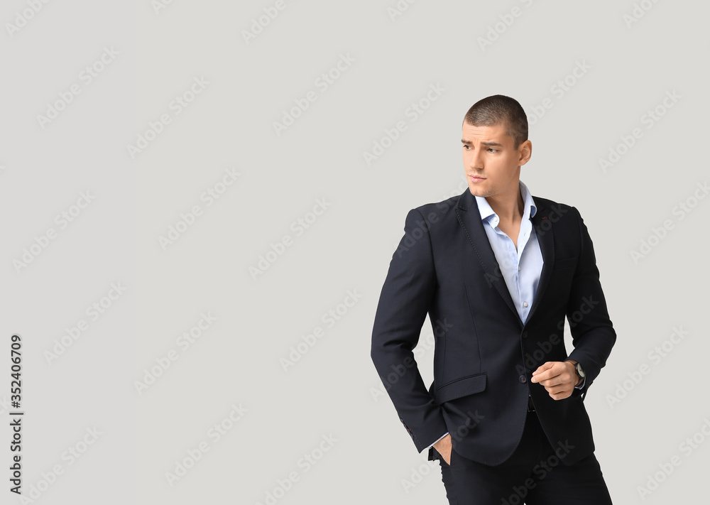 Handsome young man in elegant suit on light background Handsome young man in elegant suit on light background