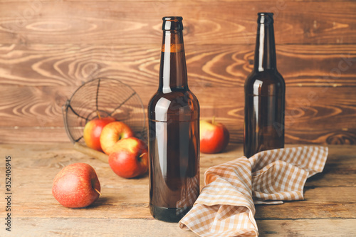 Fototapeta Naklejka Na Ścianę i Meble -  Bottles of apple cider on wooden background