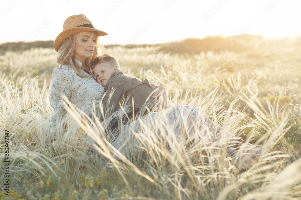 Mom with a child have fun playing in nature. A pregnant woman and a child are resting in nature.