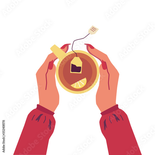 Woman's hands holding cup of tea with lemon - top view of hot drink