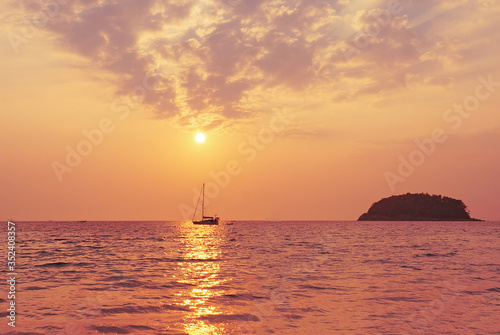 Dawn over the sea and a small sailing boat