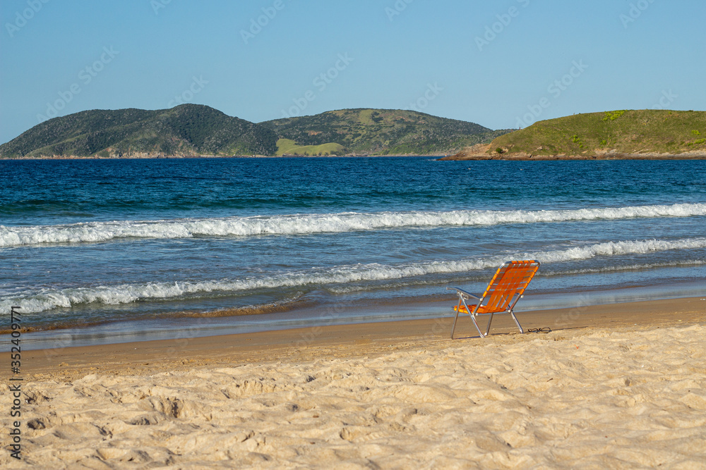 orange beach chair on beach facing the sea orange beach chair on beach facing the sea