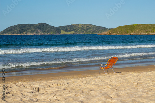 orange beach chair on beach facing the sea © Marcos