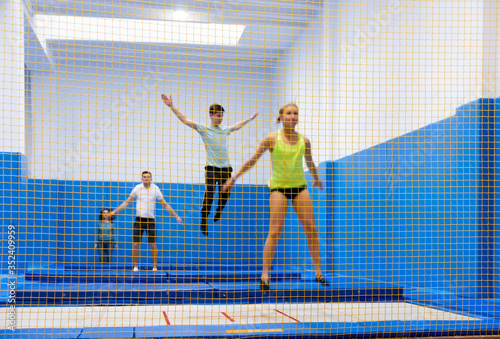 Safety net in trampoline center, blurred people on background © JackF