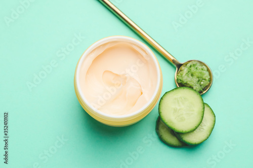 Cream with cucumber extract on color background