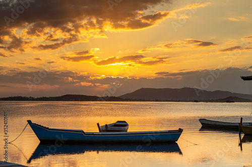 Sunset over lagoon with fisherman canoes and mountains in the background