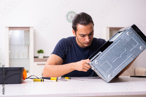 Photos Young man repairing computer at home