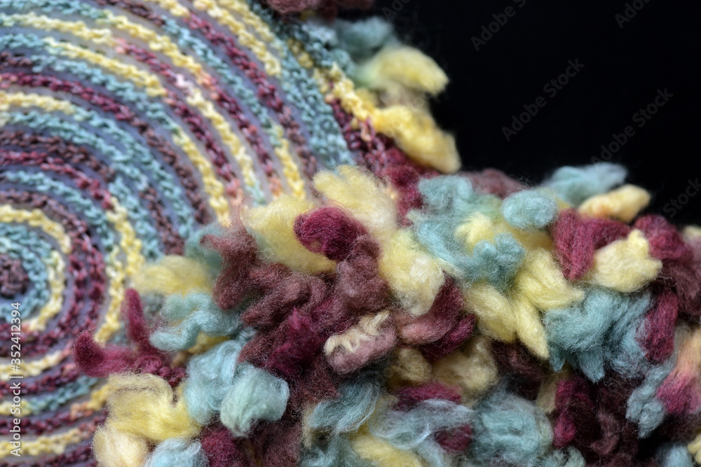 Two round crocheted fragments of fluffy multi-colored yarn close-up. Top view. Handmade concept