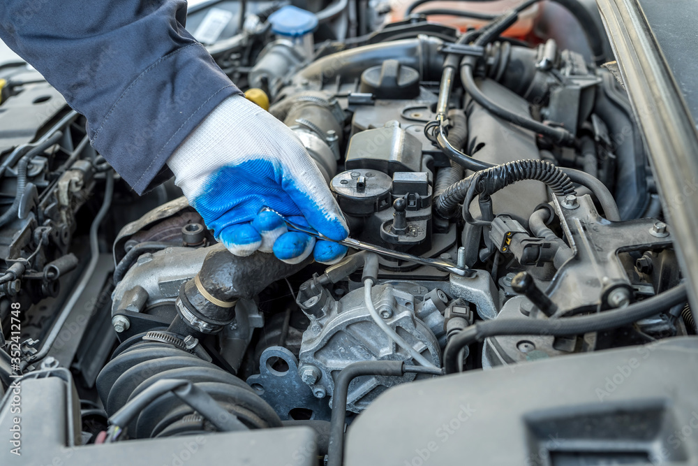 wrench key and car repair tool in mechanic's hand for service in garage