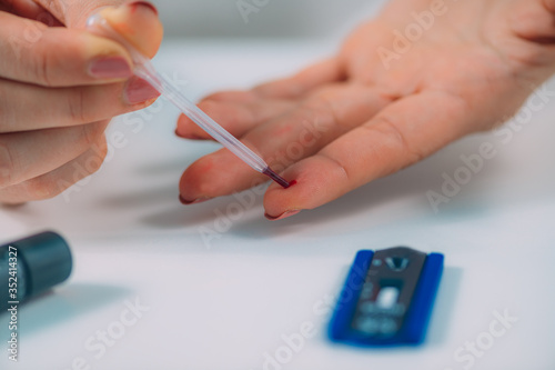 COVID19 Antibody Test. Woman Using Pipette to Take Blood Sample for Rapid Test for Corona Virus.