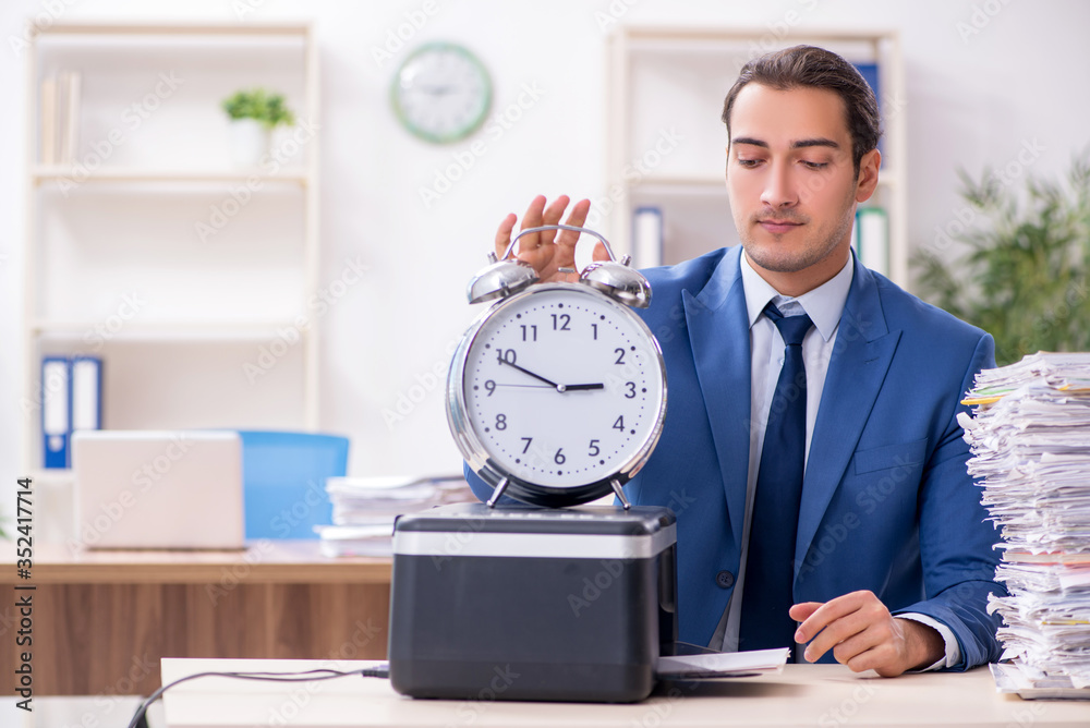 Young male employee making copies at copying machine Young male employee making copies at copying machine