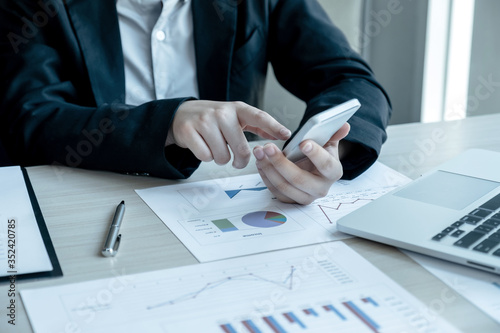 business man is sitting at a desk and calculating financial graph that show results