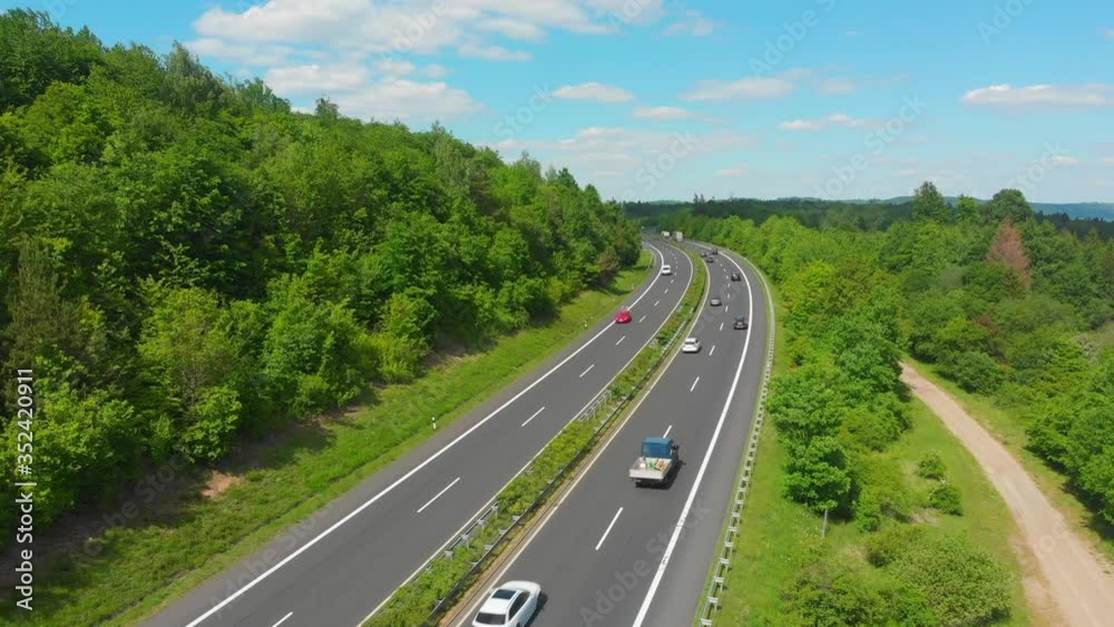 Aerial view traffic on highway through green countryside Aerial view traffic on highway through green countryside