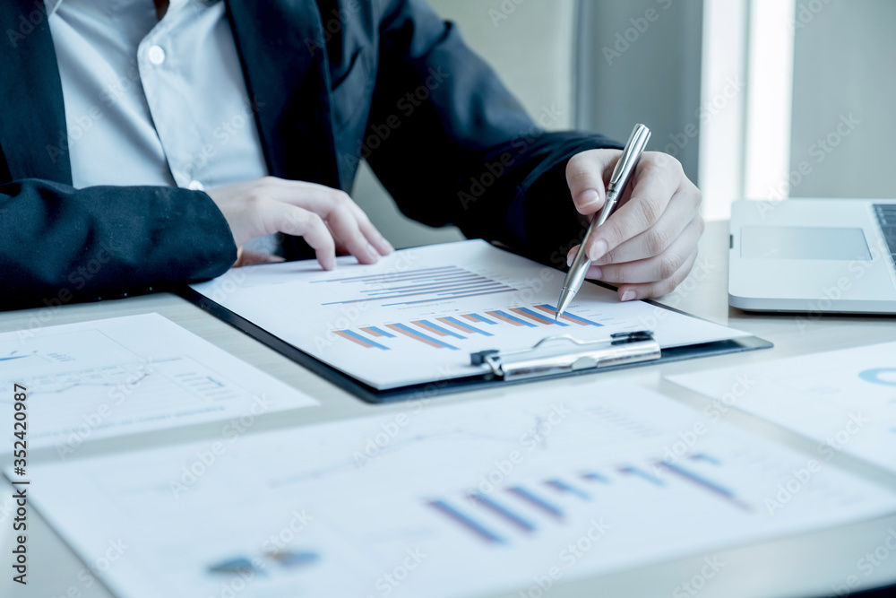 business man is sitting at a desk and calculating financial graph that show results business man is sitting at a desk and calculating financial graph that show results